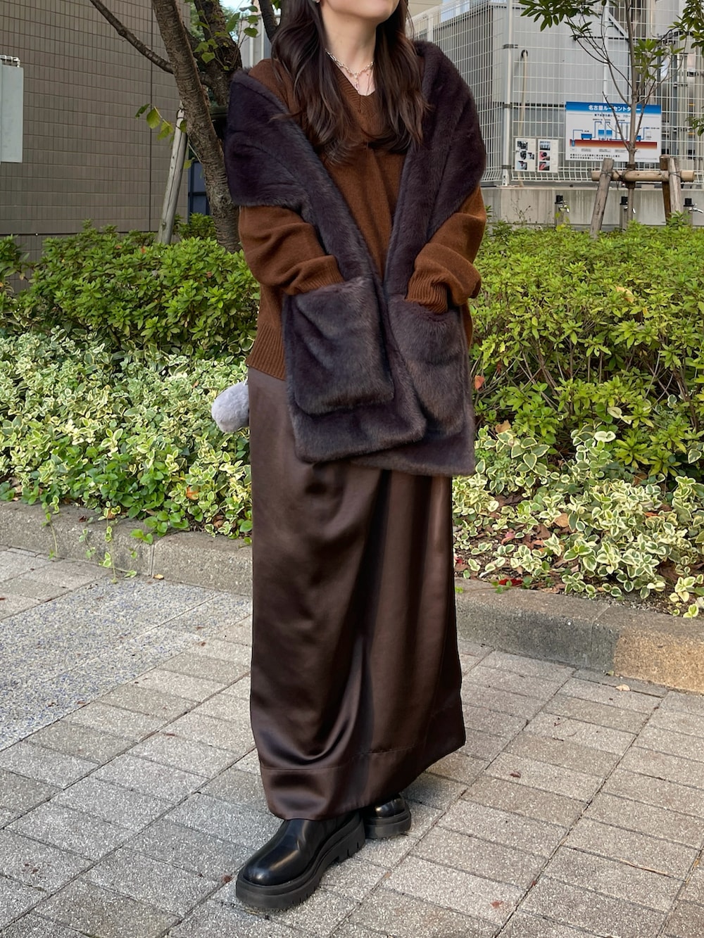 ブラック系のブーツ、ブラウン系のニット/セーター、ブラウン系のスカートを着用したレディースの秋コーディネートの3枚目の写真