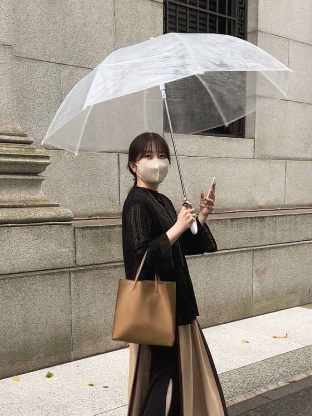 ブラック系のシャツ/ブラウス、ベージュ系のベスト、ブラック系のスカートを着用したレディースの秋コーディネートの2枚目の写真