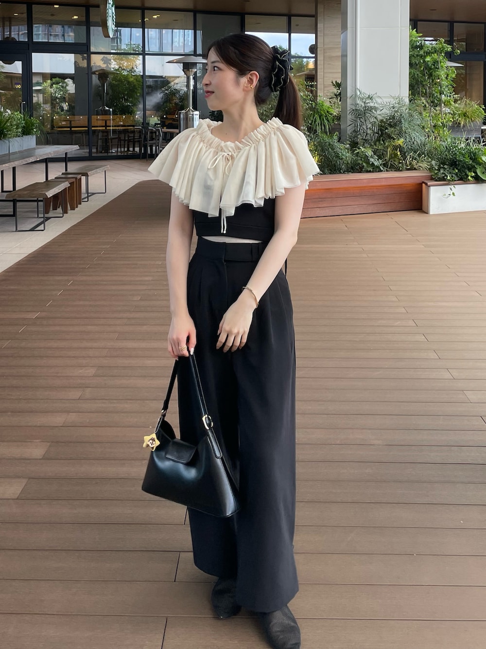 ブラック系のハンドバッグ、ブラック系のその他パンツ、ブラック系のトップスを着用したレディースの夏コーディネートの2枚目の写真
