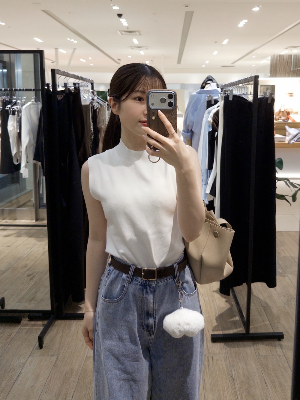 ホワイト系のニット/セーター、ブルー系のデニムパンツ、ホワイト系のサンダルを着用したレディースの夏コーディネートの4枚目の写真