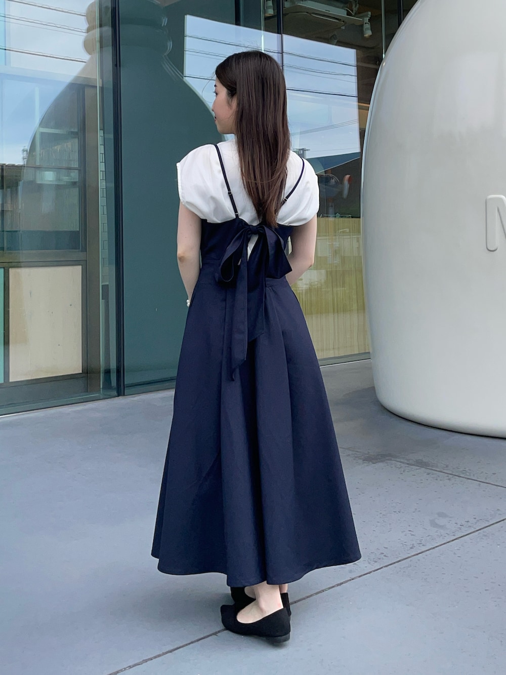 ホワイト系のシャツ/ブラウス、ブラック系のパンプス、ベージュ系のバッグを着用したレディースの夏コーディネートの2枚目の写真