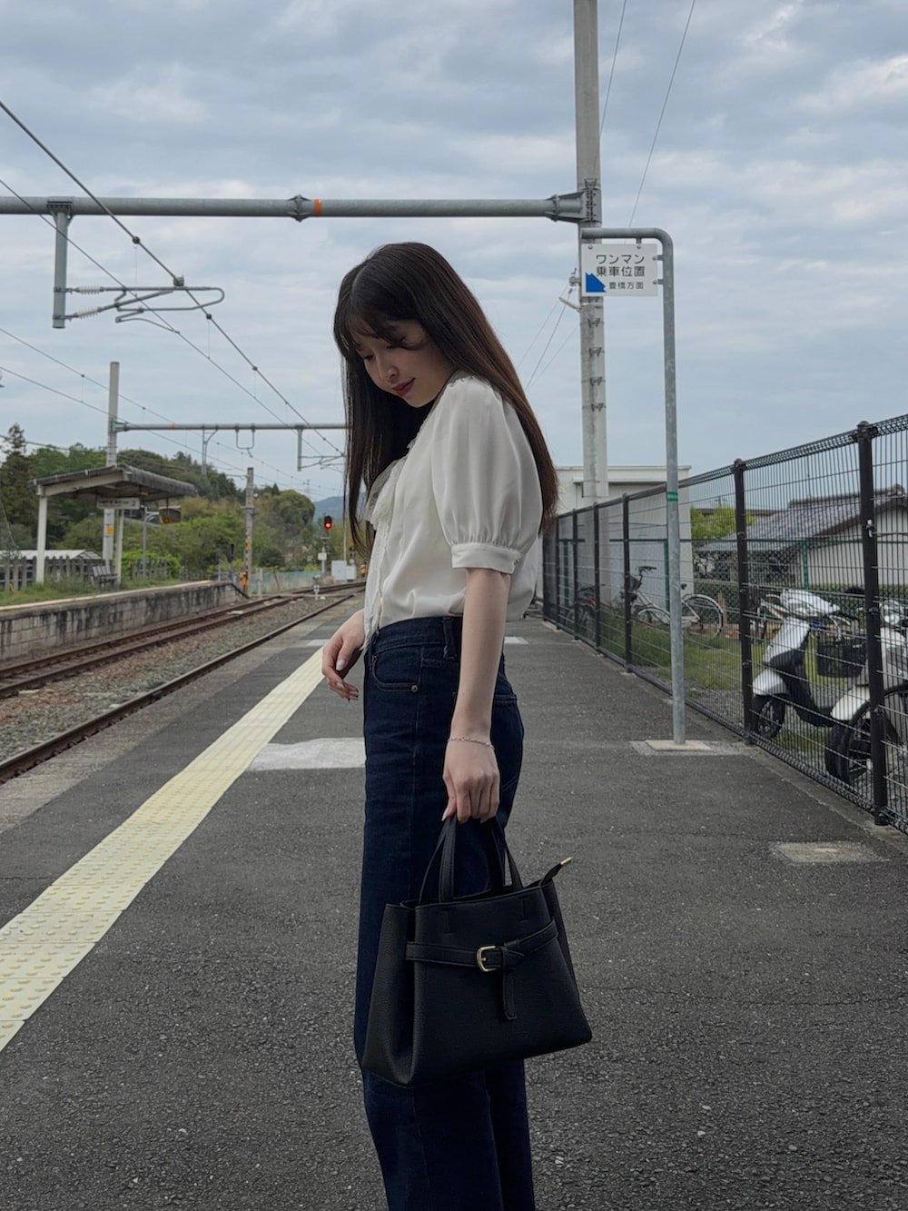 ホワイト系のシャツ/ブラウス、ブラック系のショルダーバッグ、ブルー系のパンツを着用したレディースの春コーディネートの2枚目の写真
