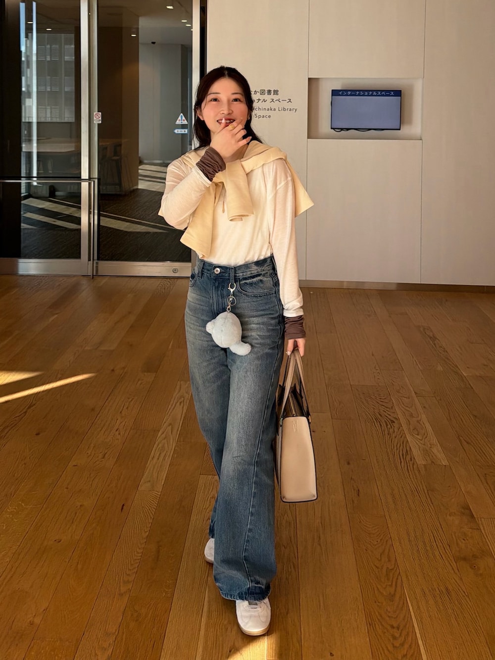 ホワイト系のカーディガン/ボレロ、ブルー系のその他パンツ、グレー系のスニーカーを着用したレディースの冬コーディネートの2枚目の写真