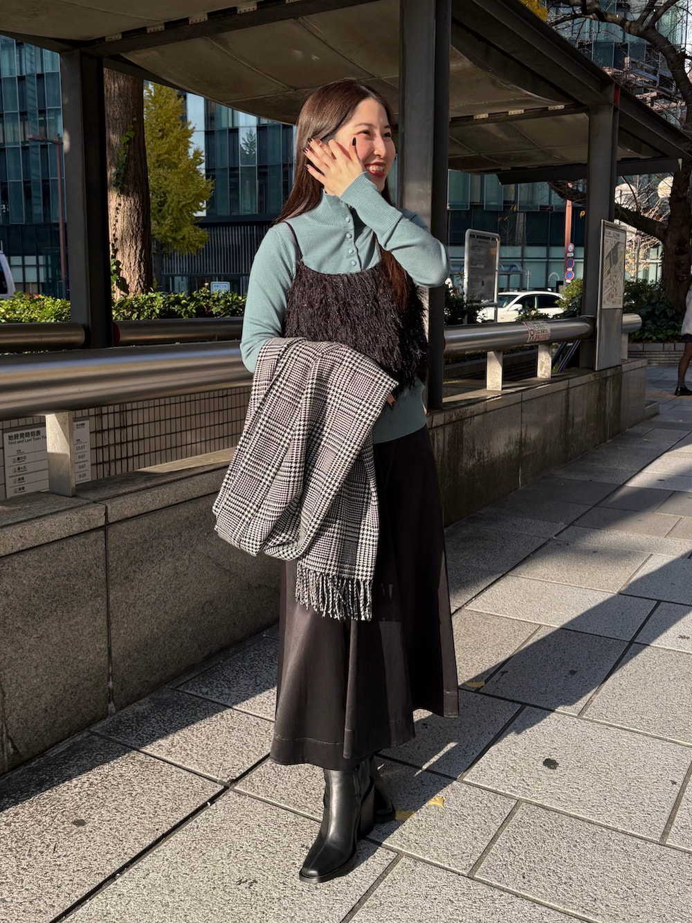 ブラック系のスカート、ブルー系のニット/セーター、ブラック系のシャツ/ブラウスを着用したレディースの冬コーディネートの2枚目の写真