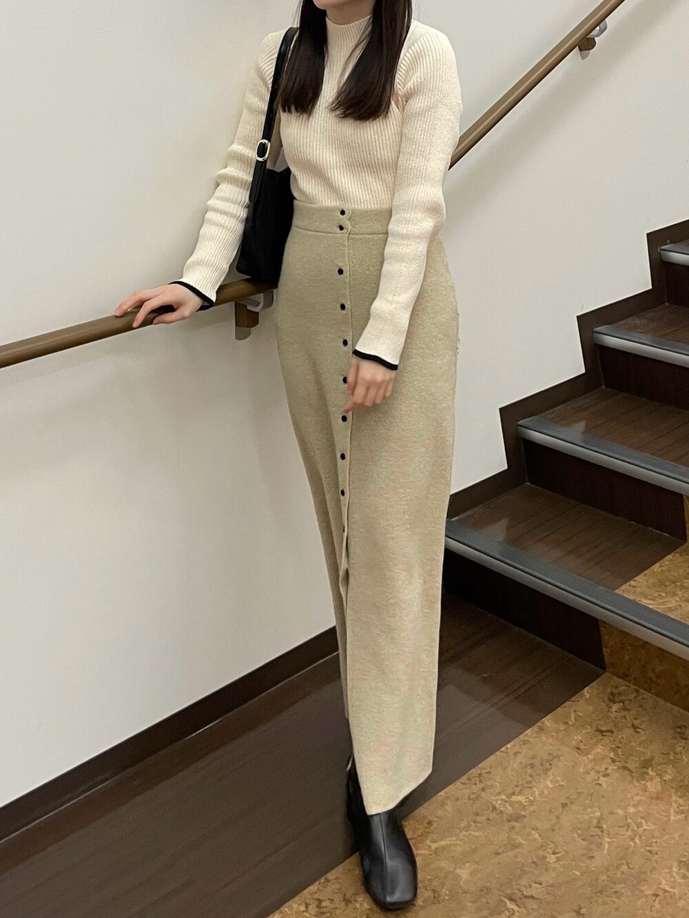 ホワイト系のニット/セーター、ホワイト系のスカート、ブラック系のブーツを着用したレディースの冬コーディネートの3枚目の写真