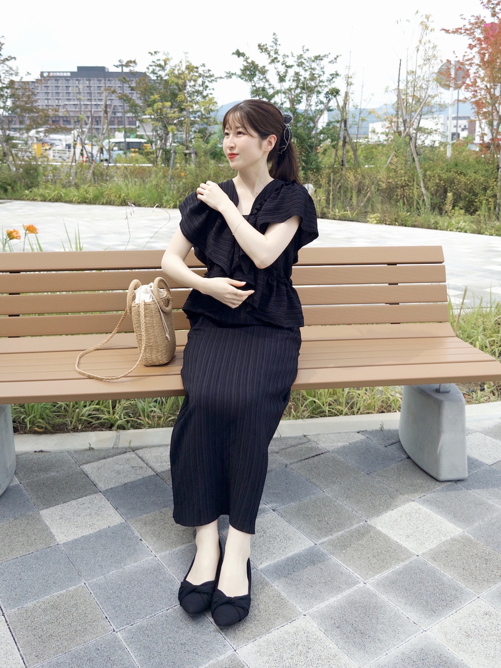 ブラック系のワンピース、ブラウン系のショルダーバッグ、ブラック系のパンプスを着用したレディースの夏コーディネートの2枚目の写真
