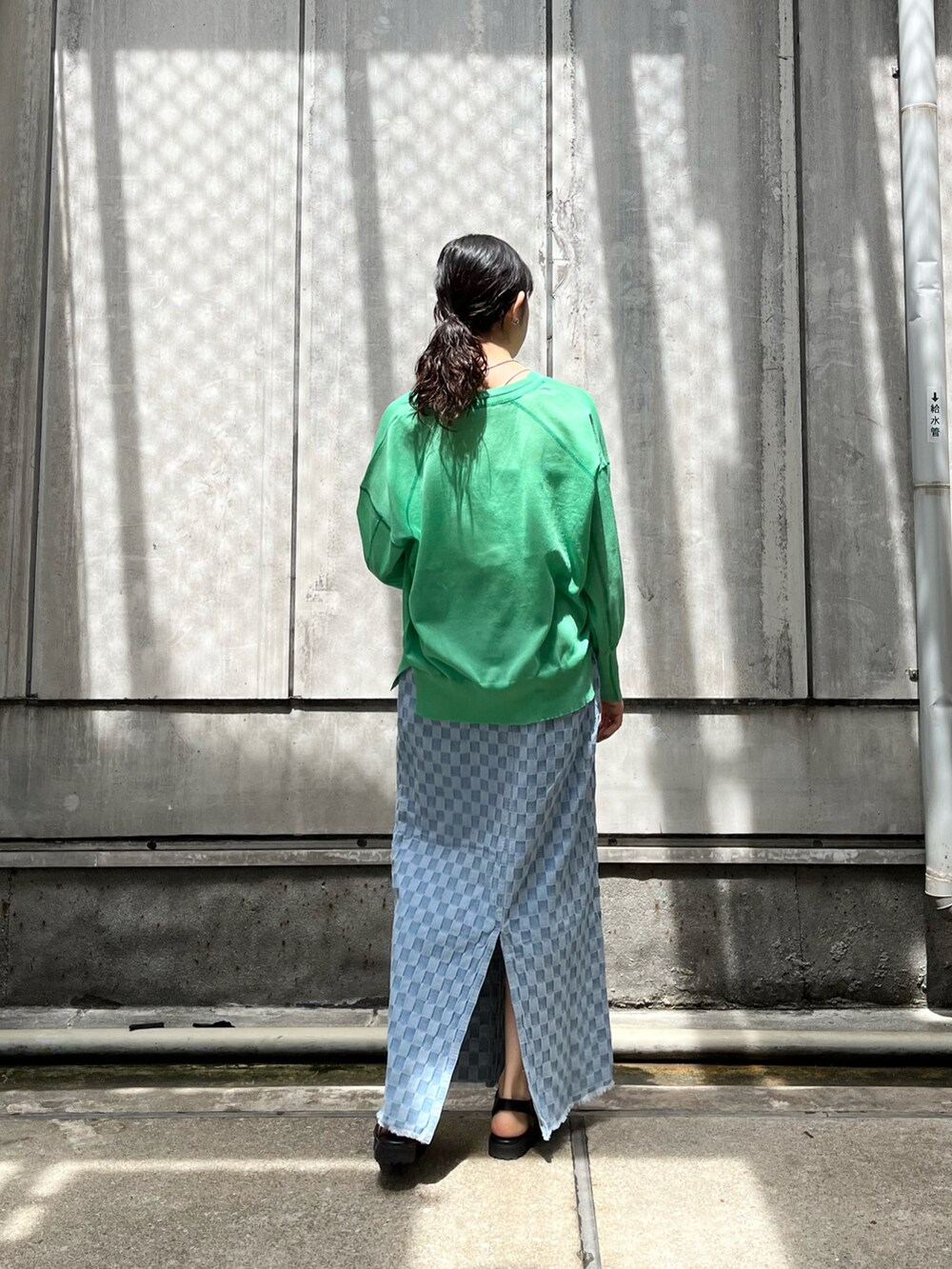 ブラック系のサンダル、ブルー系のスカート、グリーン系のカーディガン/ボレロを着用したレディースの春コーディネートの2枚目の写真