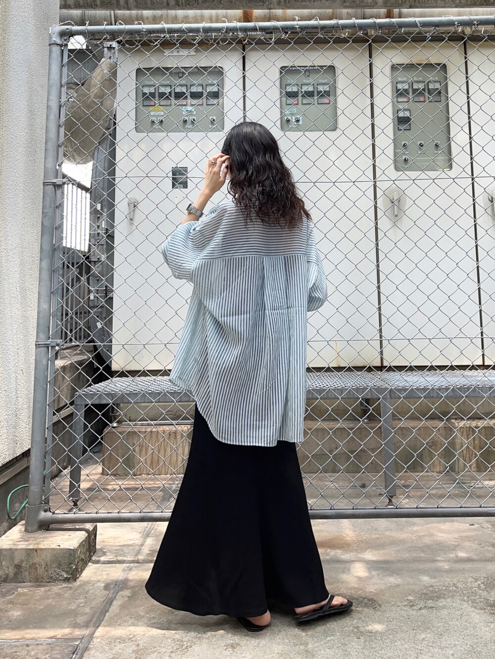 ブルー系のシャツ/ブラウス、ブラック系のスカートを着用したレディースの夏コーディネートの2枚目の写真