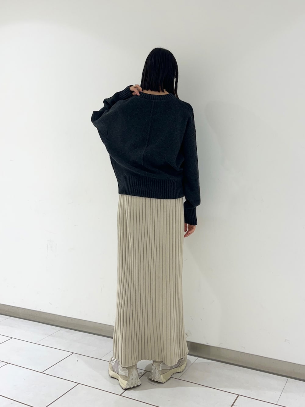 ベージュ系のスカート、グレー系のニット/セーターを着用したレディースの冬コーディネートの2枚目の写真