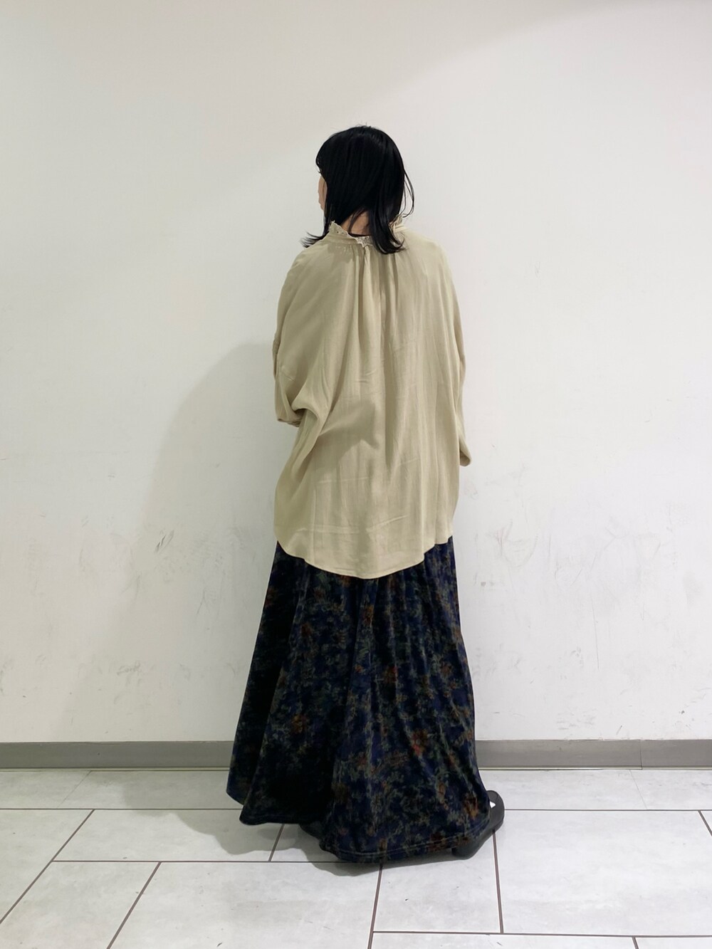 ブルー系のスカート、ベージュ系のシャツ/ブラウスを着用したレディースの冬コーディネートの2枚目の写真