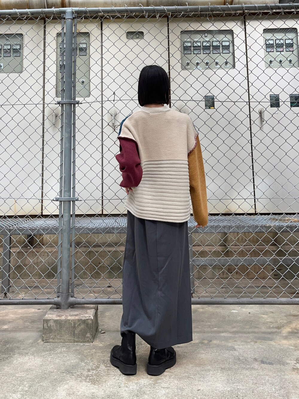 ブラック系のブーツ、ブラック系のスカート、ブルー系のニット/セーターを着用したレディースの秋コーディネートの2枚目の写真