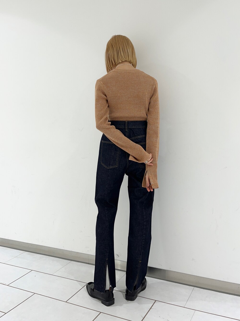 ブルー系のデニムパンツ、オレンジ系のニット/セーターを着用したレディースの冬コーディネートの2枚目の写真