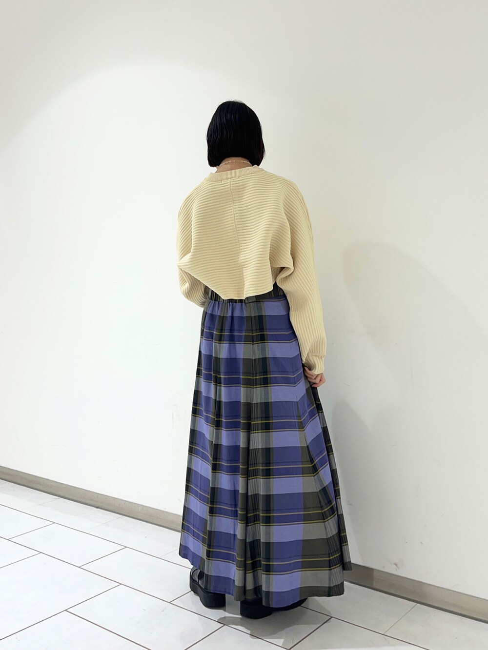 ホワイト系のカーディガン/ボレロ、パープル系のスカートを着用したレディースの秋コーディネートの2枚目の写真