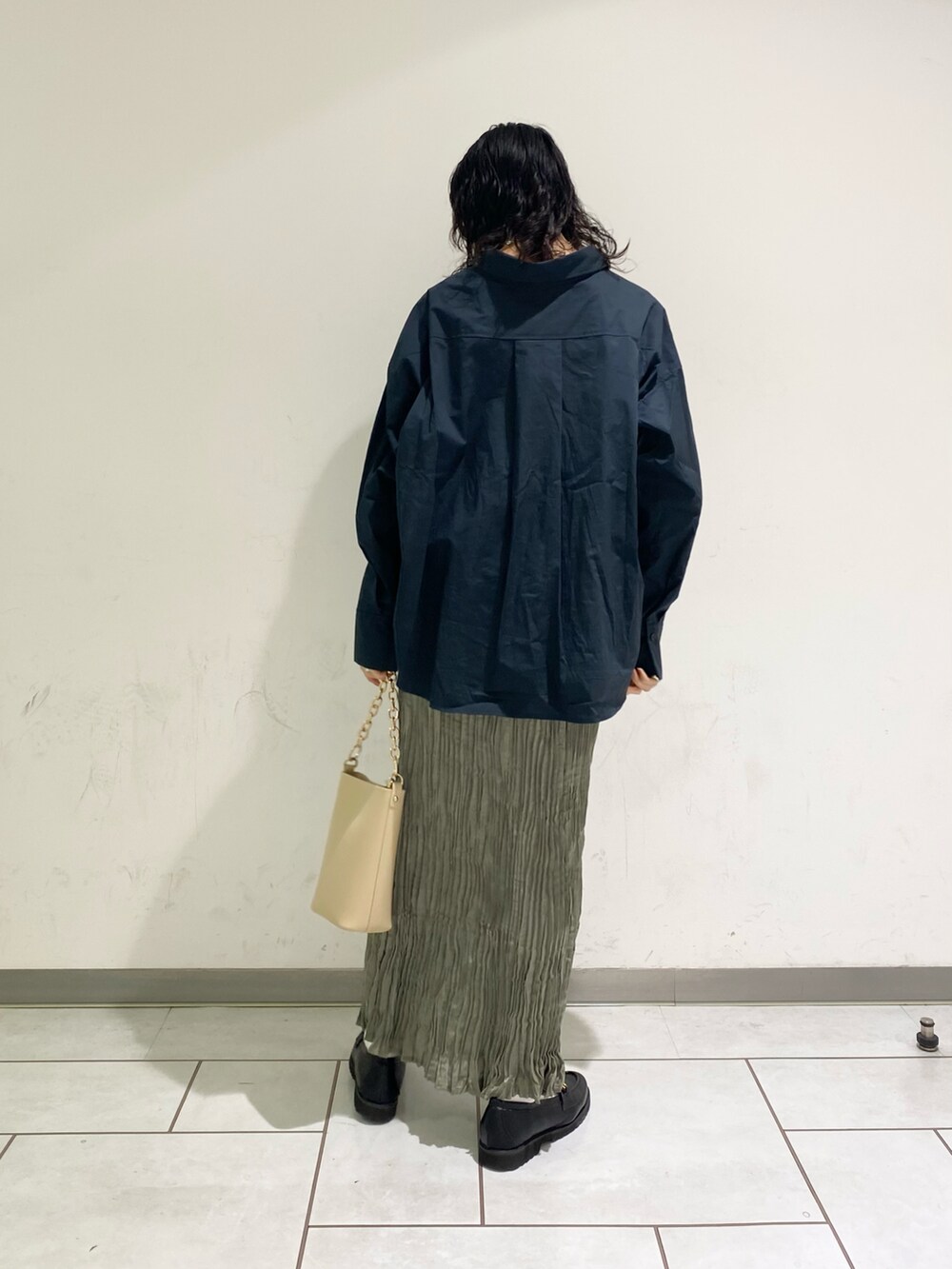 ベージュ系のショルダーバッグ、ブルー系のワンピースを着用したレディースの冬コーディネートの2枚目の写真