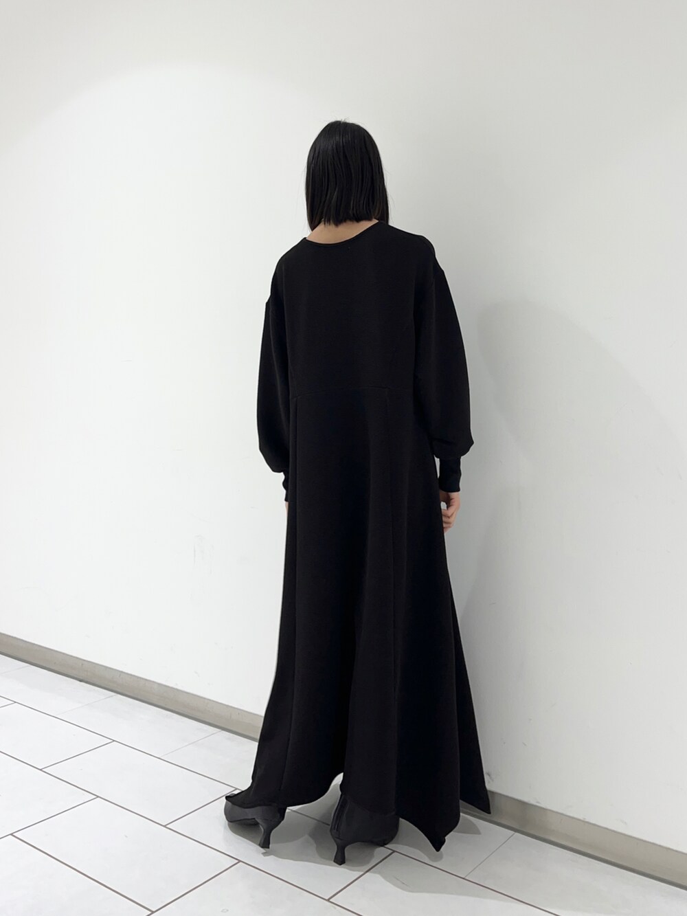 ブラック系のワンピースを着用したレディースの冬コーディネートの2枚目の写真