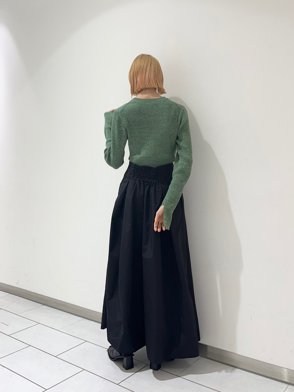 ブラック系のその他パンツ、グリーン系のニット/セーターを着用したレディースの春コーディネートの2枚目の写真