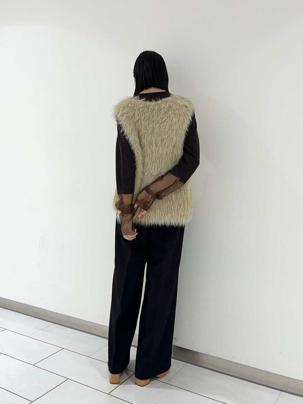 ベージュ系のベスト、ブラウン系のニット/セーター、ブラック系のその他パンツを着用したレディースの秋コーディネートの2枚目の写真