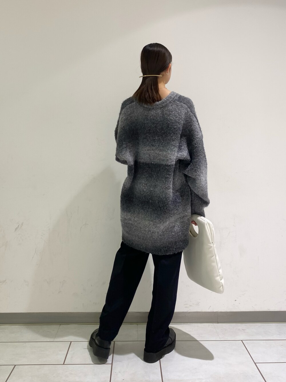 ホワイト系のハンドバッグ、ブルー系のその他パンツ、ブラック系のニット/セーターを着用したレディースの秋コーディネートの2枚目の写真