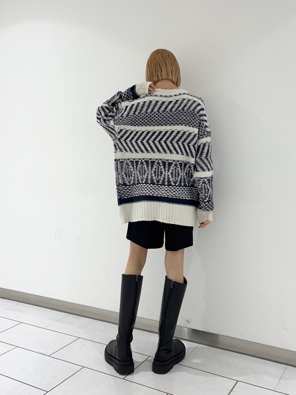 ブルー系のニット/セーターを着用したレディースの冬コーディネートの2枚目の写真