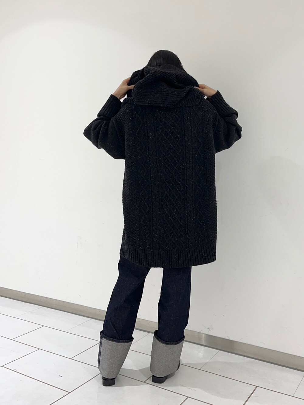 ブラック系のローファー、ブルー系のデニムパンツ、ブラック系のニット/セーターを着用したレディースの秋コーディネートの3枚目の写真