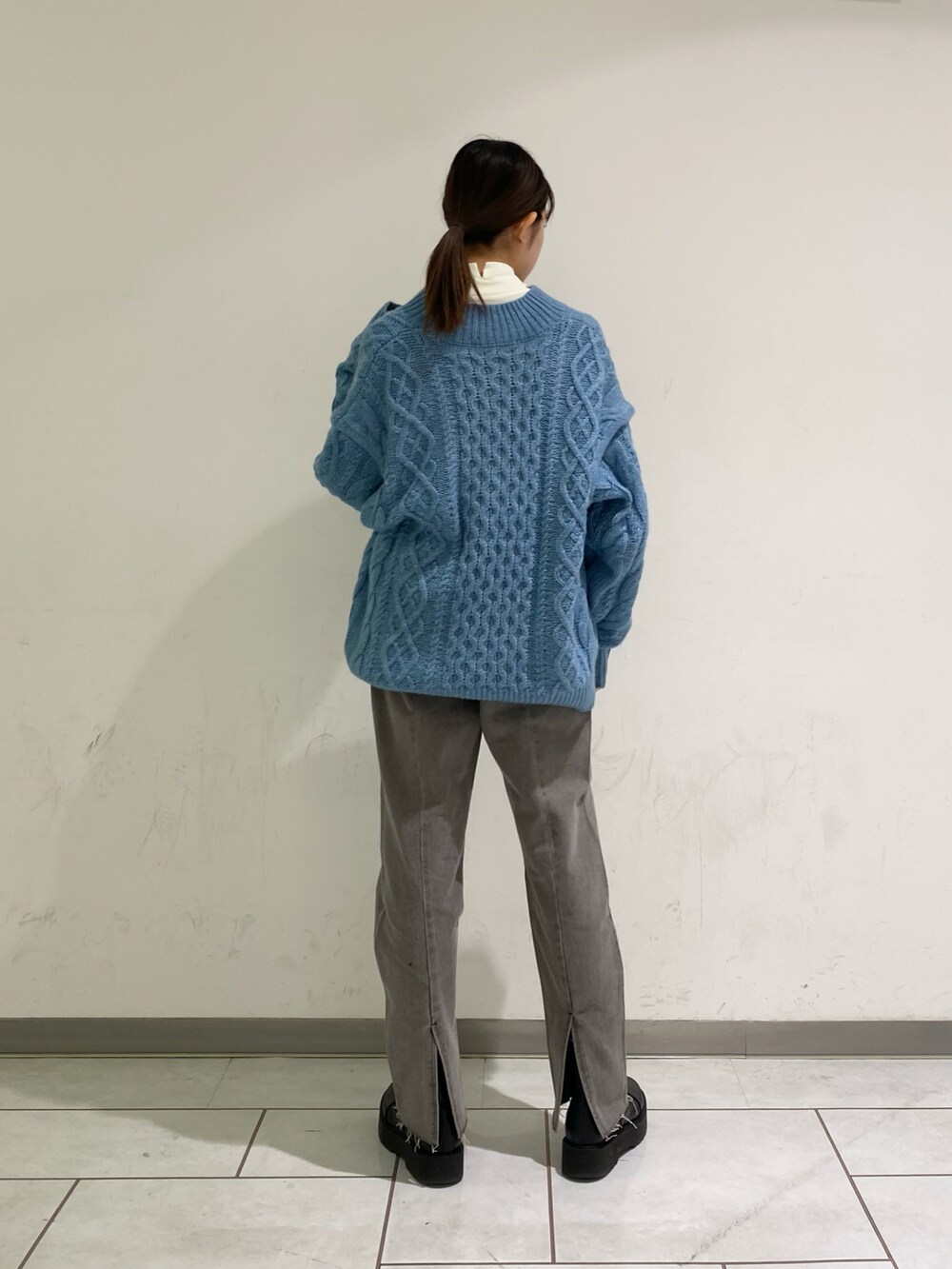 ホワイト系のTシャツ/カットソー、ブルー系のニット/セーター、グレー系のデニムパンツを着用したレディースの冬コーディネートの2枚目の写真