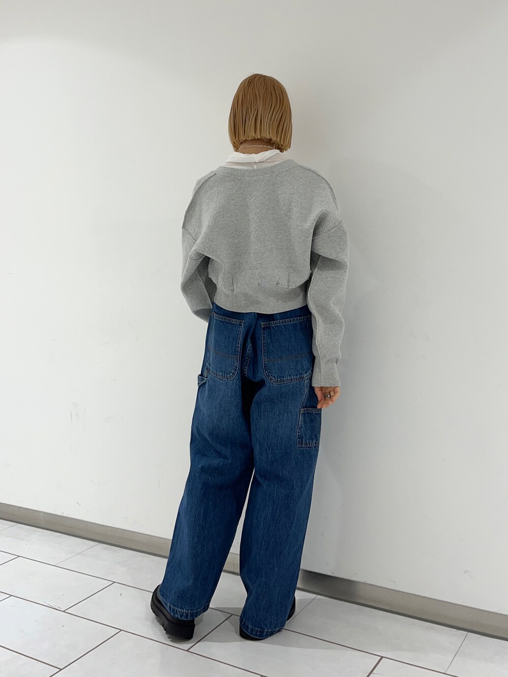 ホワイト系のTシャツ/カットソー、グレー系のカーディガン/ボレロ、ブルー系のデニムパンツを着用したレディースの冬コーディネートの2枚目の写真