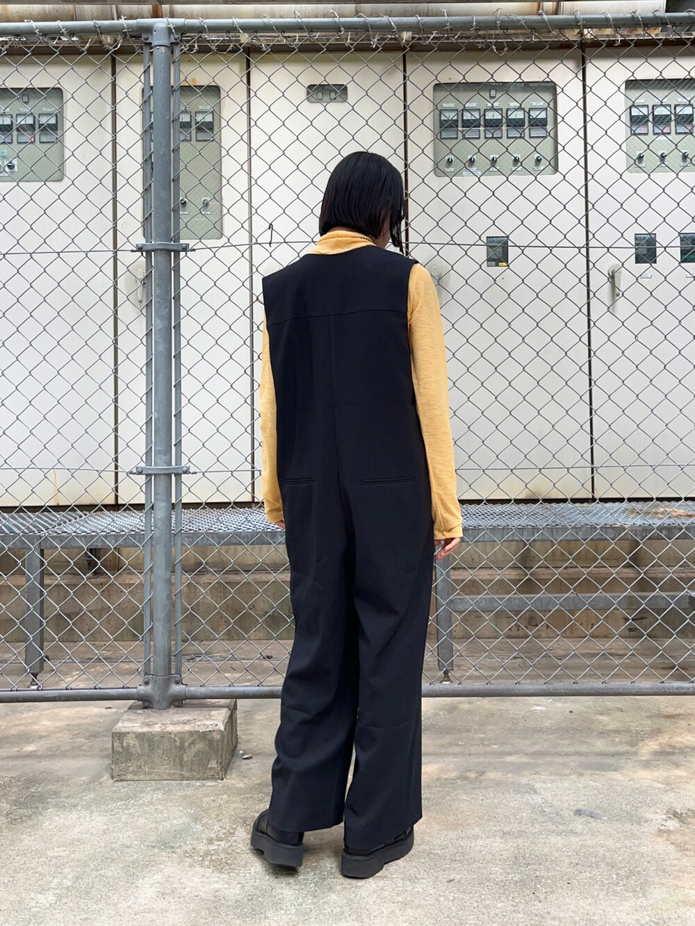 ブラック系のサロペット/オーバーオール、オレンジ系のTシャツ/カットソーを着用したレディースの秋コーディネートの2枚目の写真