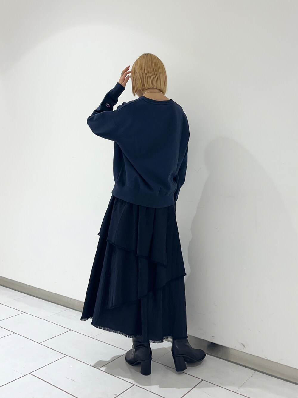 ブルー系のスカート、ブラック系のブーツを着用したレディースの冬コーディネートの2枚目の写真