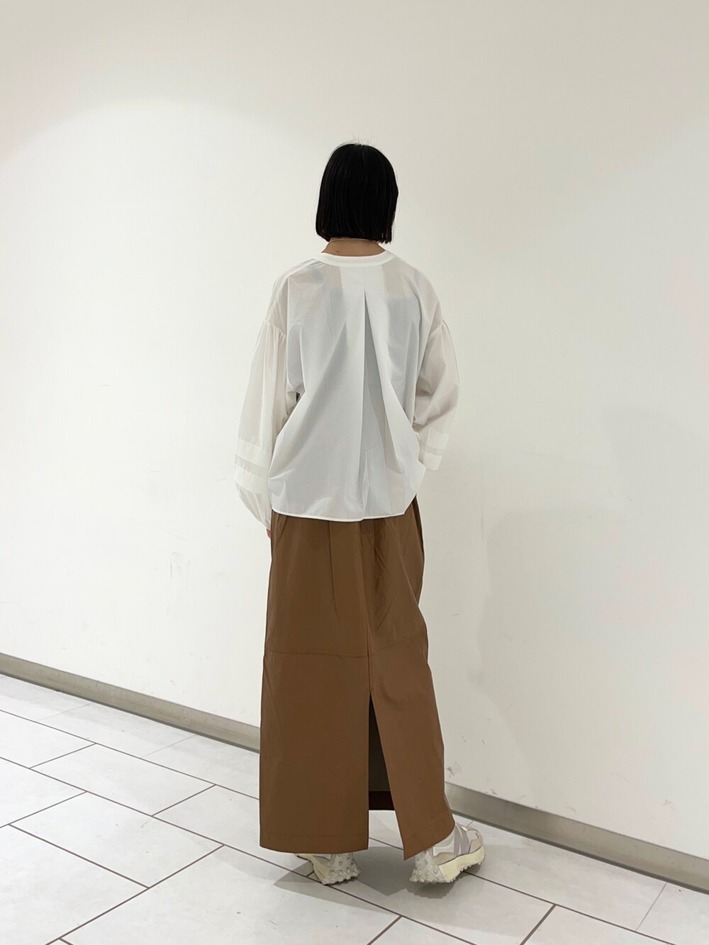 ホワイト系のシャツ/ブラウス、ブラウン系のスカートを着用したレディースの秋コーディネートの2枚目の写真