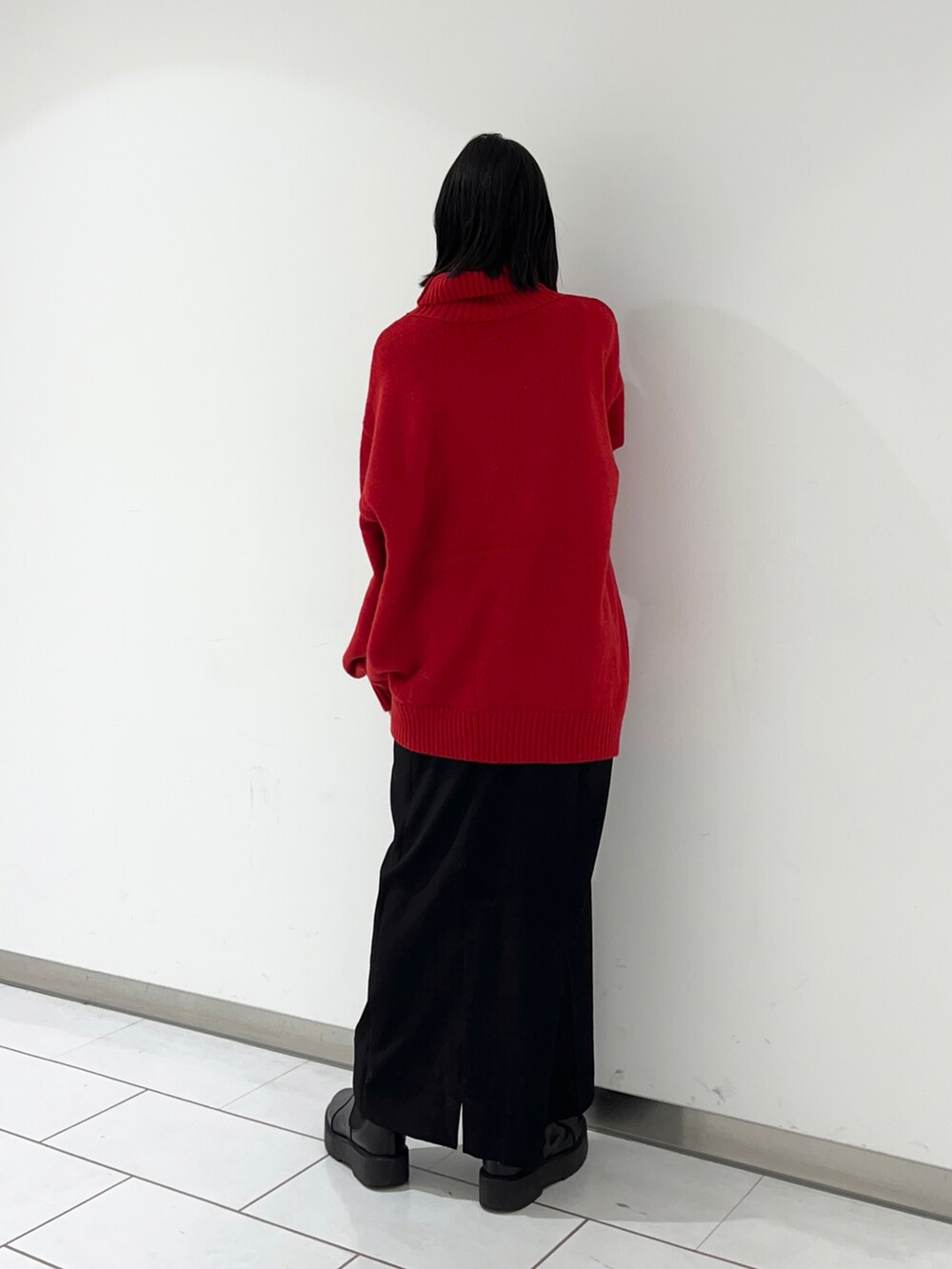 レッド系のニット/セーターを着用したレディースの冬コーディネートの2枚目の写真