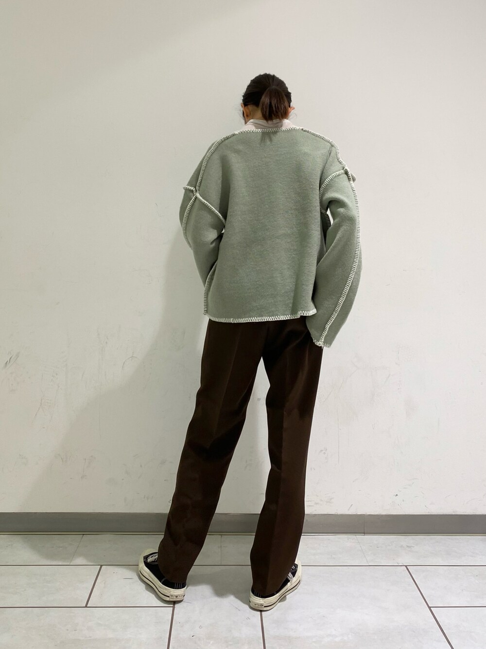 グリーン系のニット/セーター、ブラウン系のその他パンツを着用したレディースの冬コーディネートの2枚目の写真