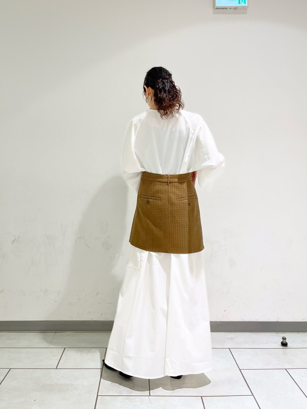 ブラック系のサンダル、ブラウン系のスカート、ホワイト系のワンピース/ドレスを着用したレディースの夏コーディネートの2枚目の写真