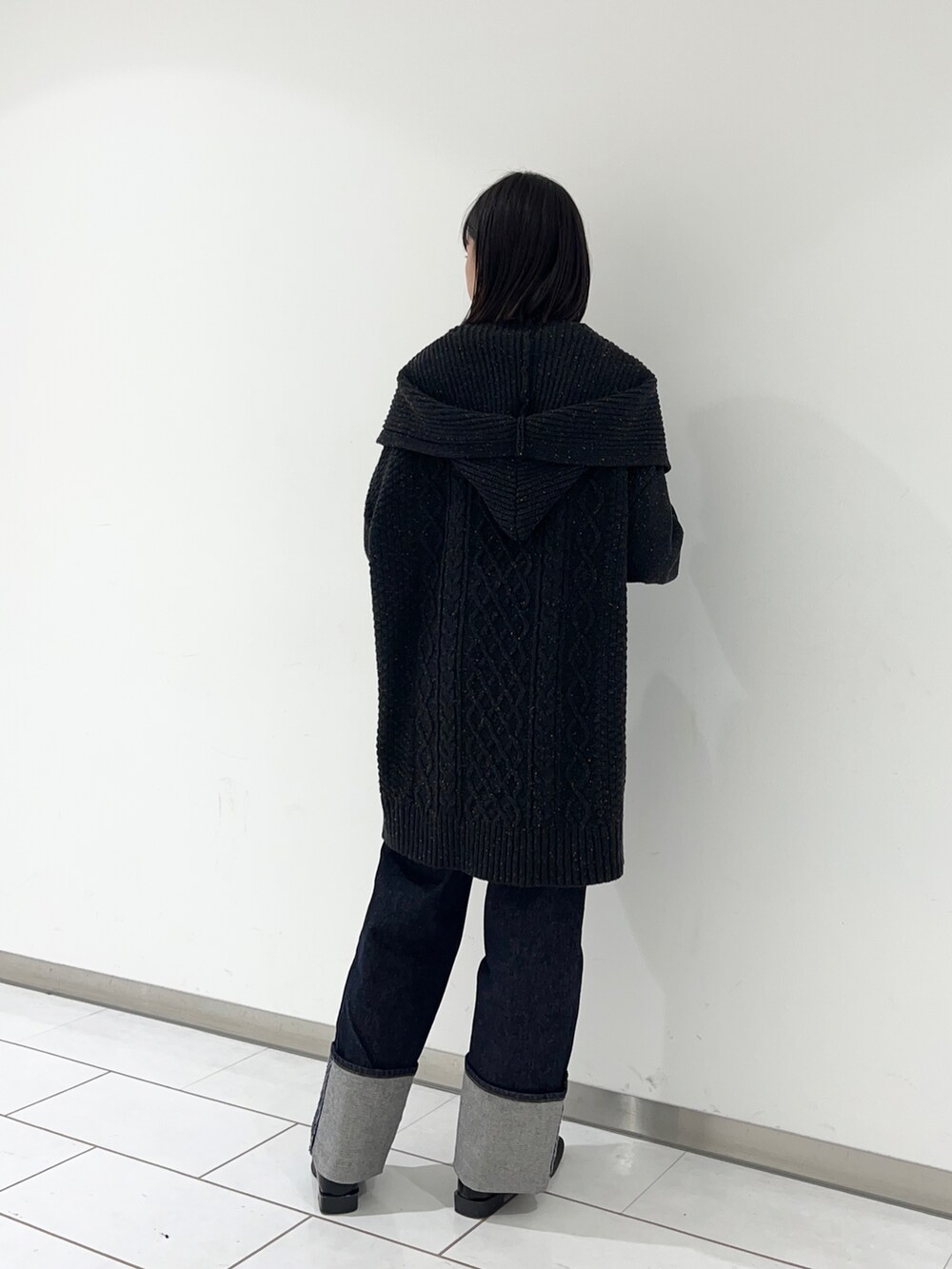 ブラック系のローファー、ブルー系のデニムパンツ、ブラック系のニット/セーターを着用したレディースの秋コーディネートの2枚目の写真