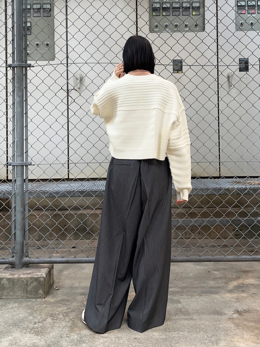 ホワイト系のニット/セーター、グレー系のその他パンツを着用したレディースの秋コーディネートの2枚目の写真