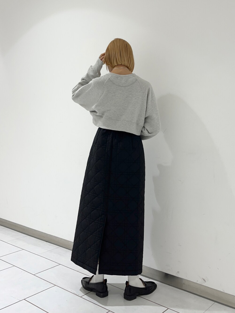 ブラック系のローファー、ブラック系のスカート、グレー系のTシャツ/カットソーを着用したレディースの冬コーディネートの2枚目の写真