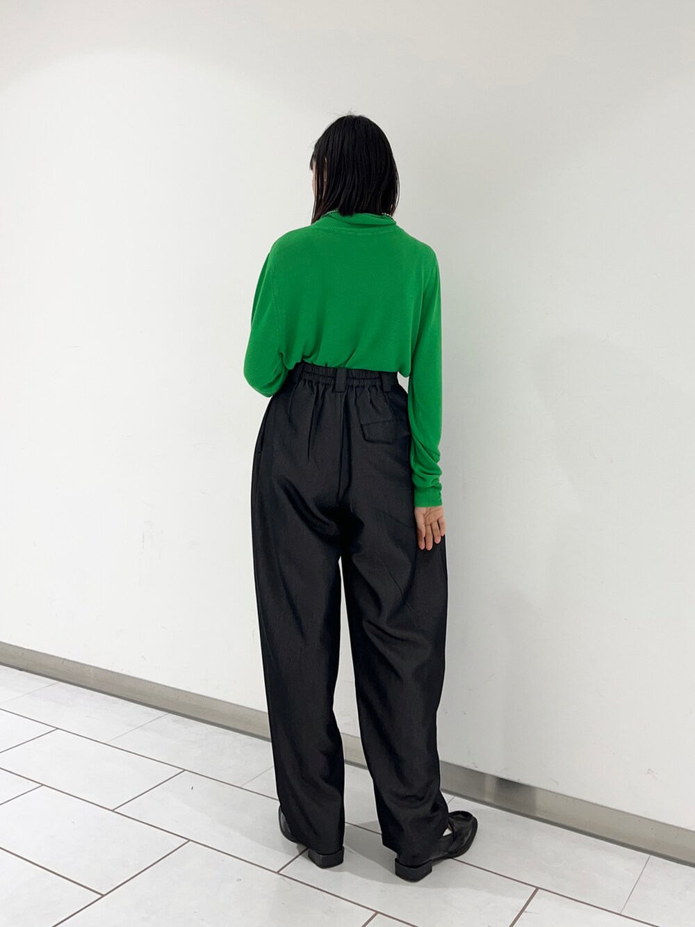 ブラック系のローファー、グレー系のその他パンツ、グリーン系のニット/セーターを着用したレディースの冬コーディネートの2枚目の写真