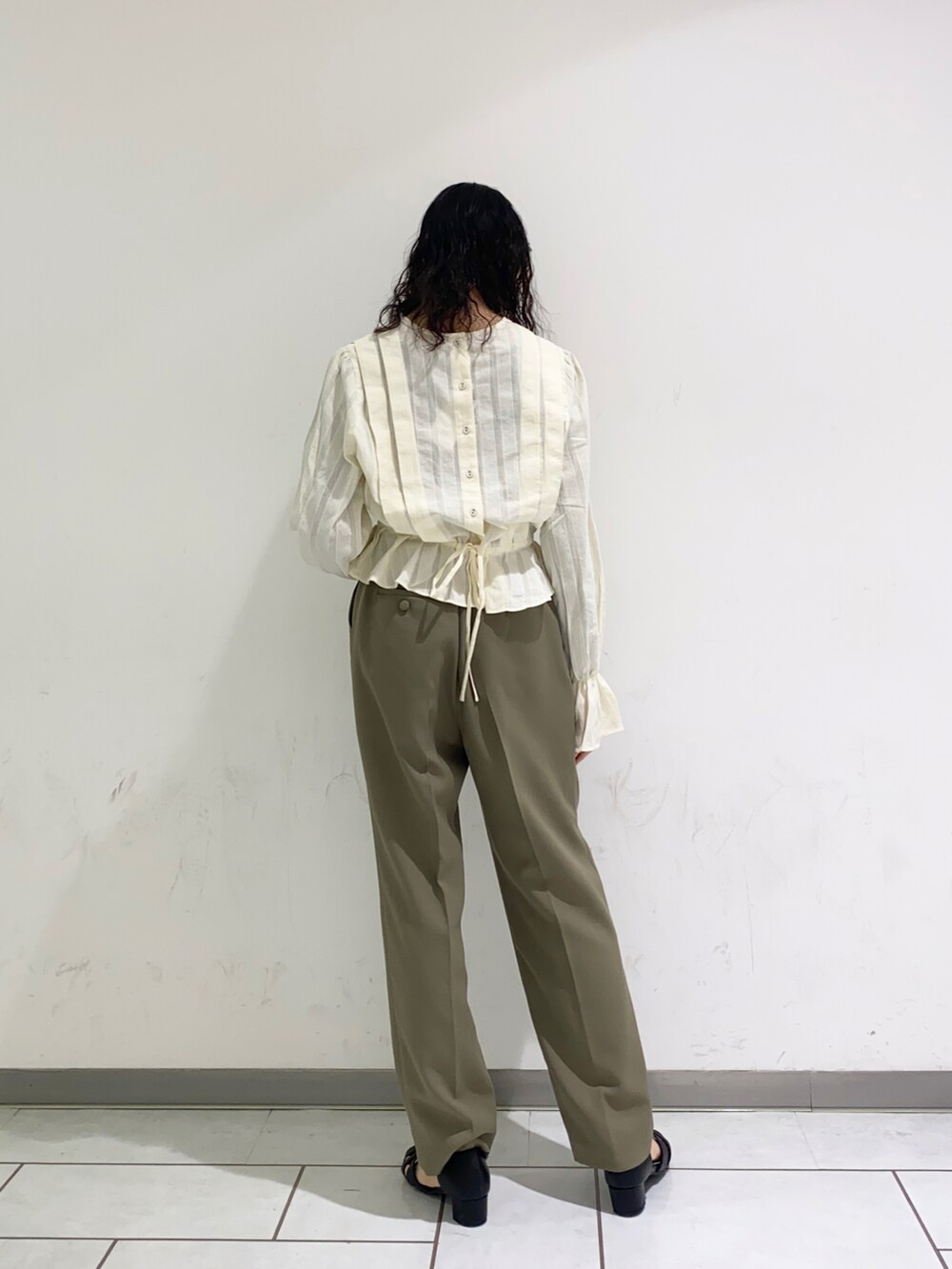 ホワイト系のシャツ/ブラウス、グリーン系のスラックス、ブラック系のサンダルを着用したレディースの春コーディネートの2枚目の写真