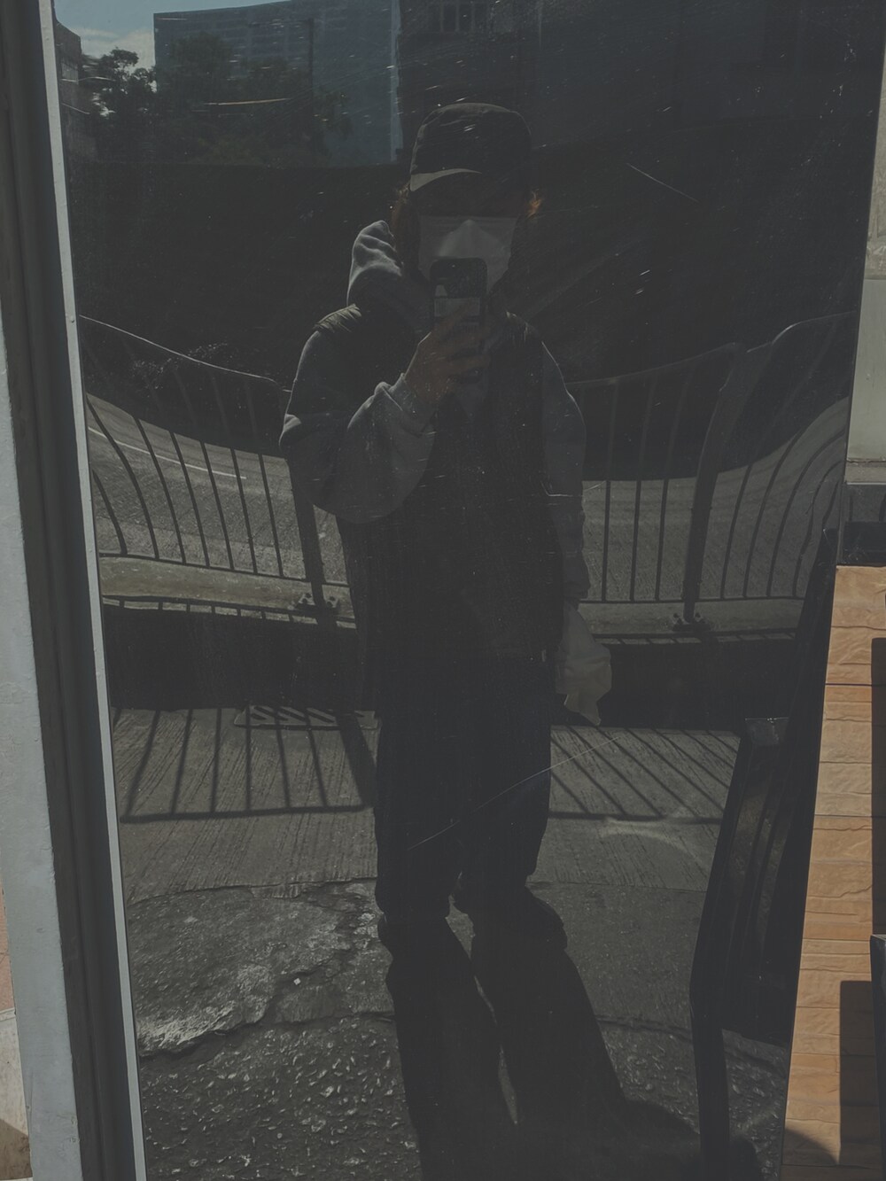 ブルー系のデニムパンツ、グリーン系のダウンベスト、ブラック系のスニーカーを着用したメンズの冬コーディネートの2枚目の写真