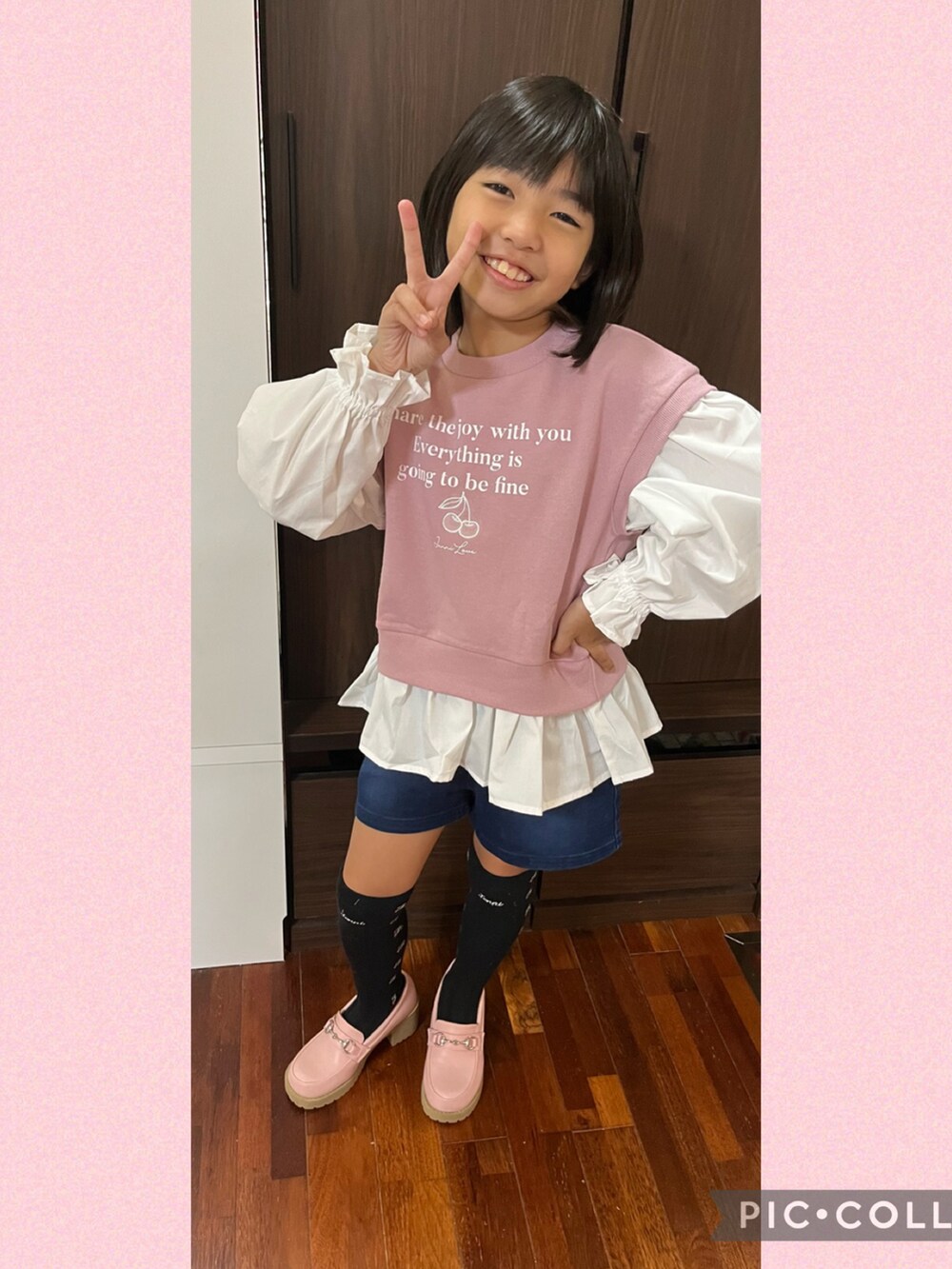 ピンク系のスウェット、ブルー系のデニムパンツ、ピンク系のローファーを着用したキッズの秋コーディネートの3枚目の写真