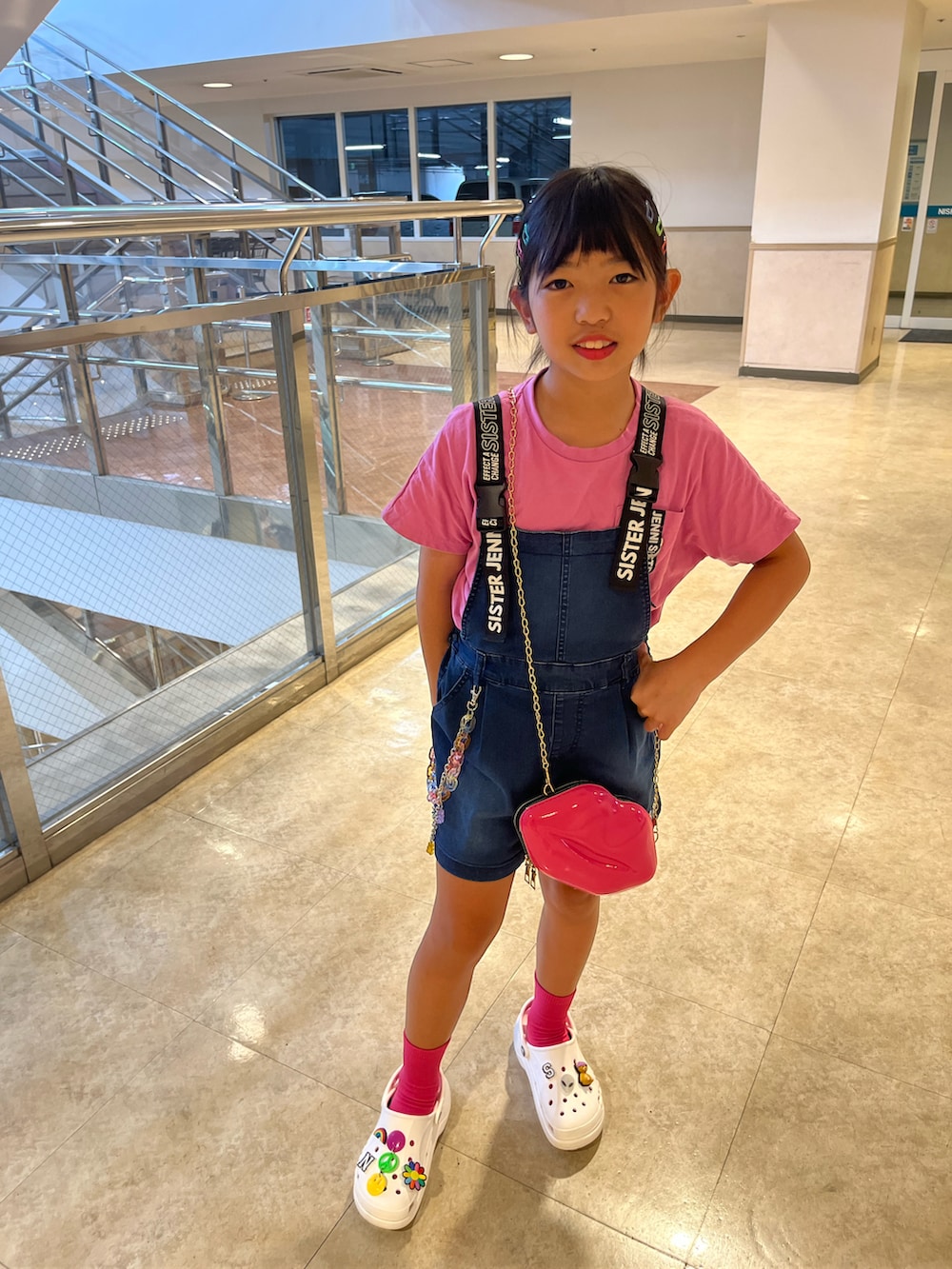 ピンク系のTシャツ/カットソー、ブルー系のサロペット/オーバーオール、ホワイト系のサンダルを着用したキッズの夏コーディネートの2枚目の写真