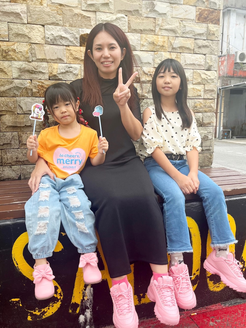 オレンジ系のTシャツ/カットソー、ピンク系のスニーカー、ホワイト系のシャツ/ブラウスを着用したキッズの春コーディネートの4枚目の写真