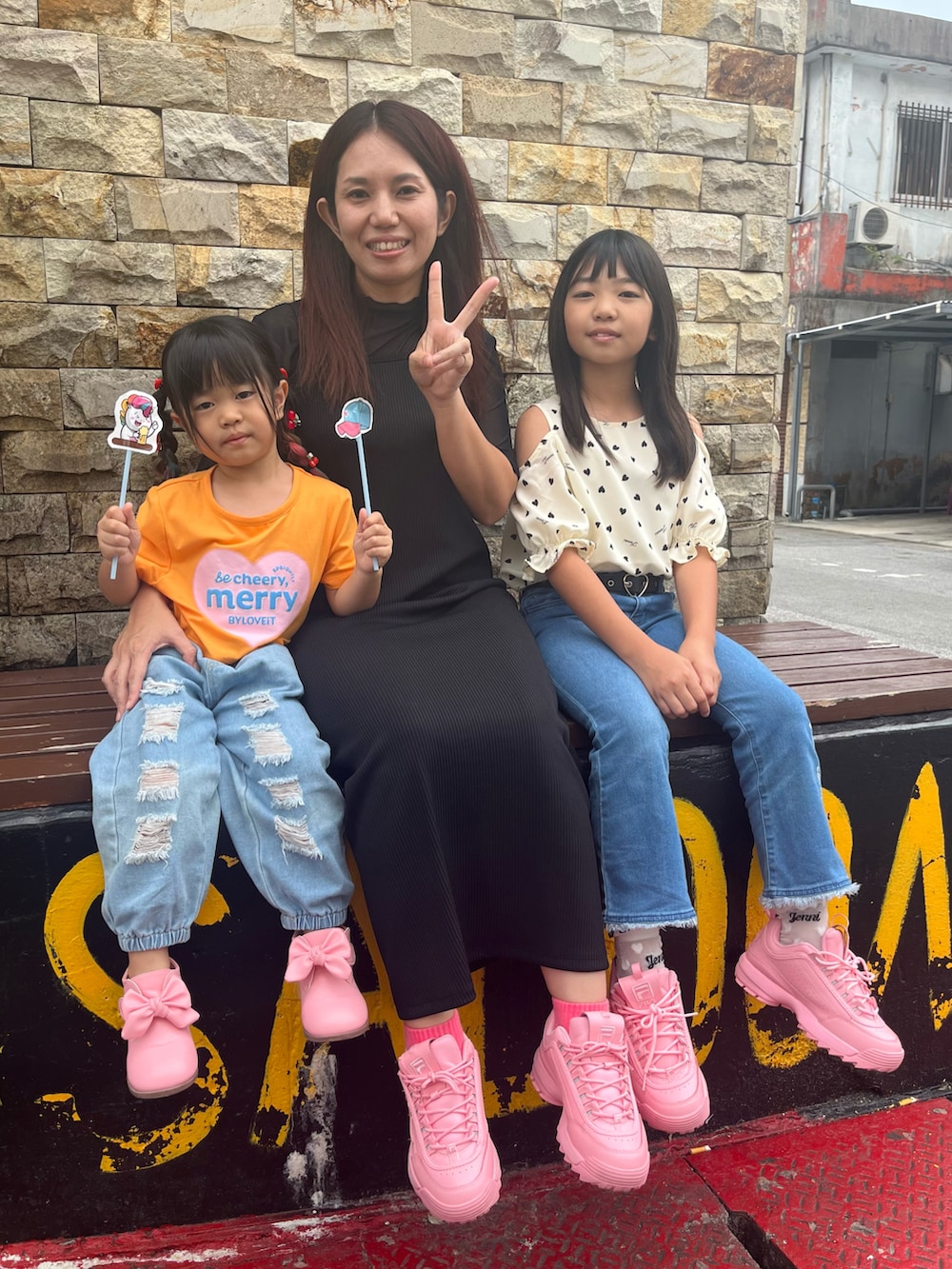 オレンジ系のTシャツ/カットソー、ピンク系のスニーカー、ホワイト系のシャツ/ブラウスを着用したキッズの春コーディネートの3枚目の写真