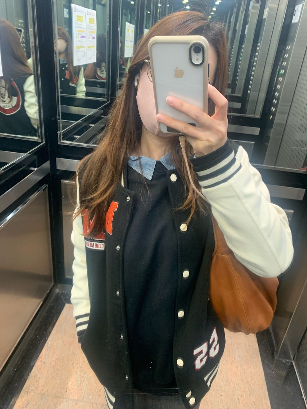 グレー系のスカート、ホワイト系のスニーカー、その他のスタジャンを着用したレディースの冬コーディネートの2枚目の写真