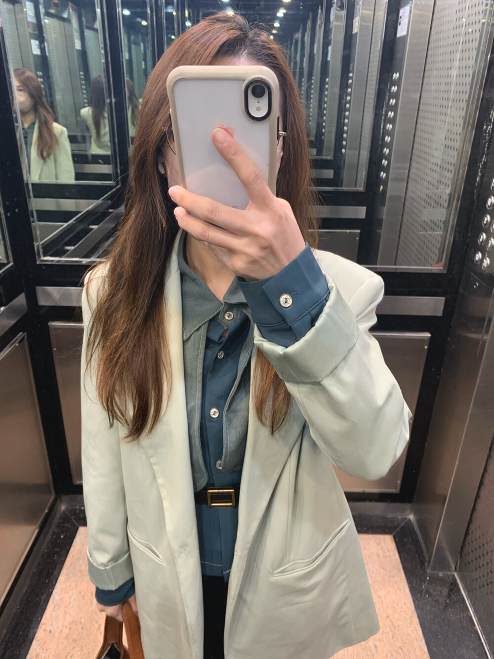 グリーン系のテーラードジャケット、グリーン系のシャツ/ブラウス、ブラウン系のショルダーバッグを着用したレディースの冬コーディネートの2枚目の写真