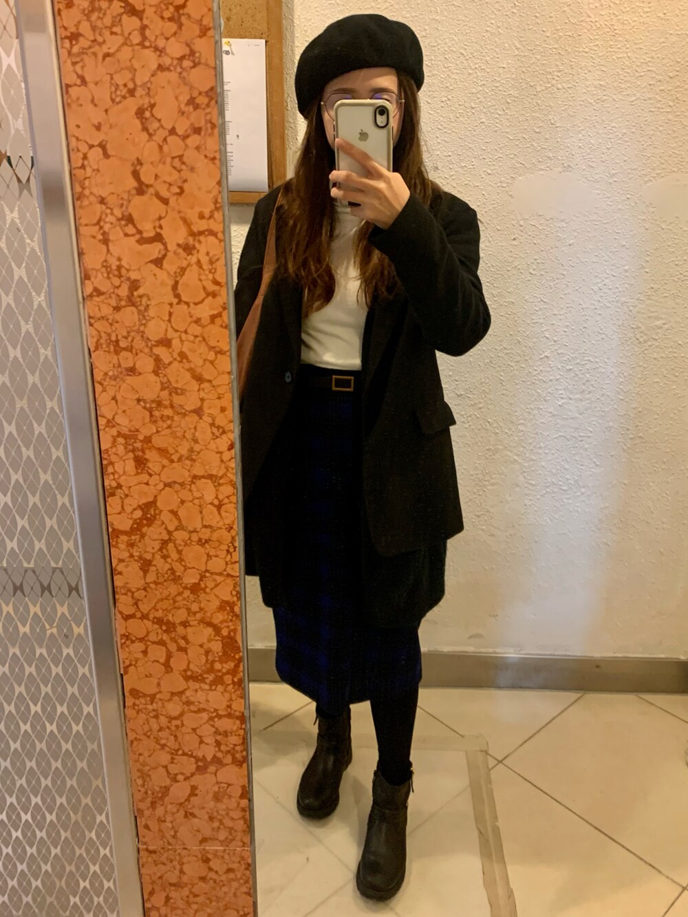 ブラウン系のショルダーバッグ、ブルー系のスカート、ブラック系のハンチング/ベレー帽を着用したレディースの冬コーディネートの2枚目の写真