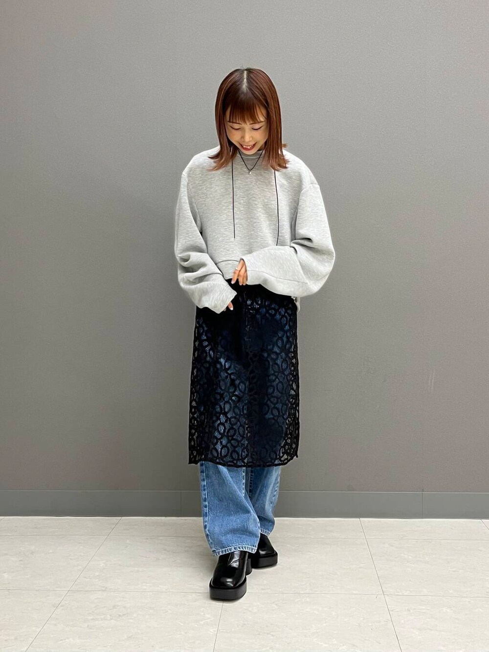 ブルー系のデニムパンツ、ブラック系のスカート、グレー系のその他トップスを着用したレディースの夏コーディネートの3枚目の写真