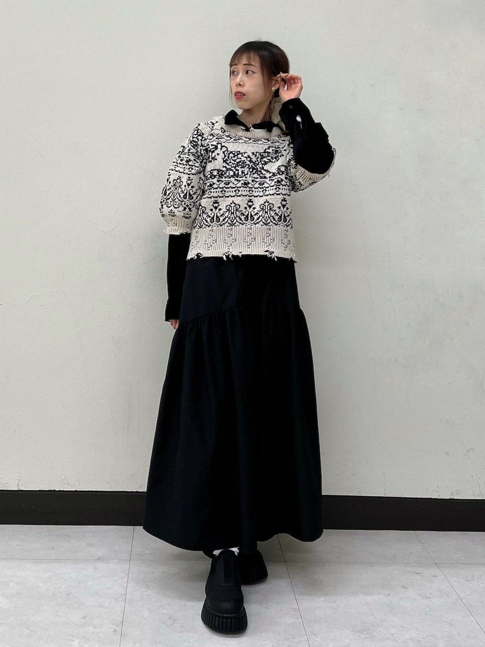 ブラック系のシャツ/ブラウス、ベージュ系のニット/セーター、ブラック系のスカートを着用したレディースの冬コーディネートの3枚目の写真