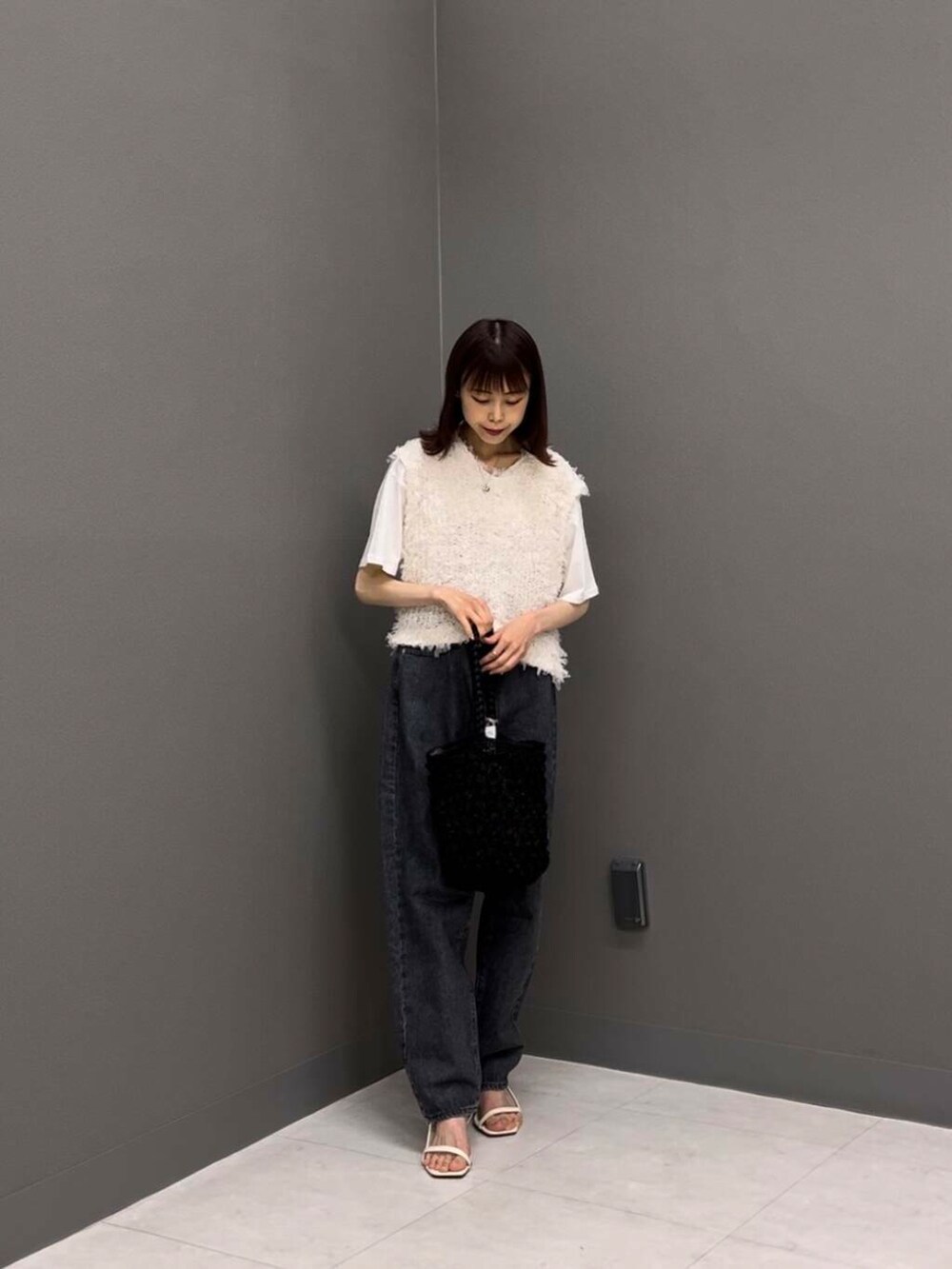 ホワイト系のTシャツ/カットソー、ブラック系のショルダーバッグ、ホワイト系のベストを着用したレディースの夏コーディネートの3枚目の写真