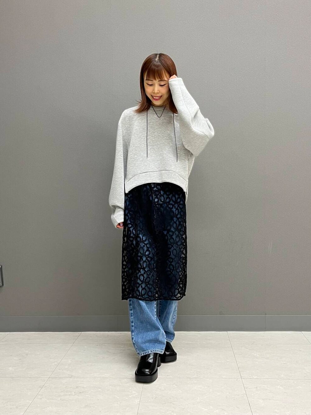 ブルー系のデニムパンツ、ブラック系のスカート、グレー系のその他トップスを着用したレディースの夏コーディネートの2枚目の写真