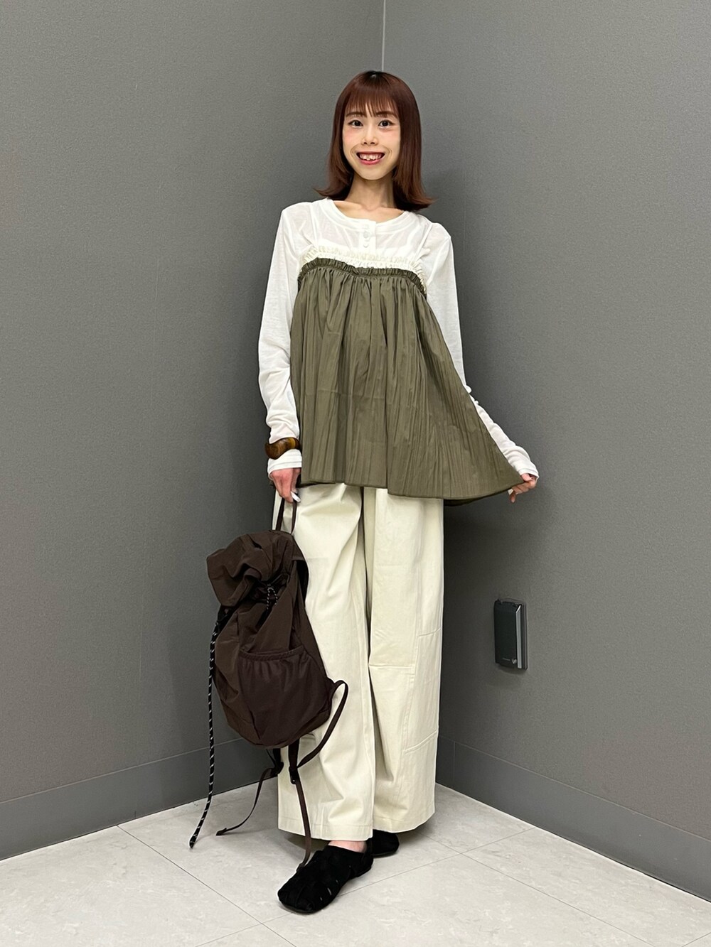 ホワイト系のカーディガン/ボレロ、グリーン系のその他トップス、ブラウン系のバックパック/リュックを着用したレディースの春コーディネートの3枚目の写真